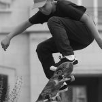 man in black shirt jumping with skateboard